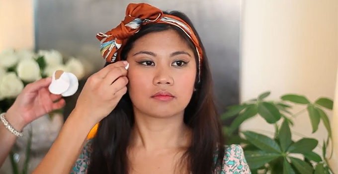 A girl remove extra blush from face with tissue