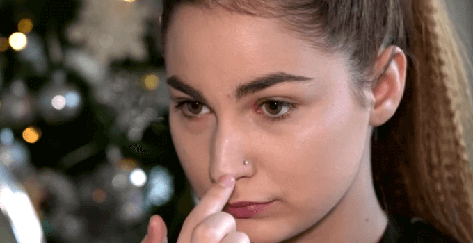 girl applying highlighter on tip of her nose