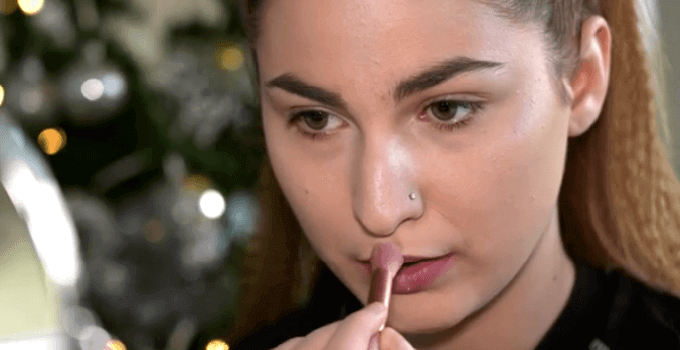 girl applying highlighter on her upper lip