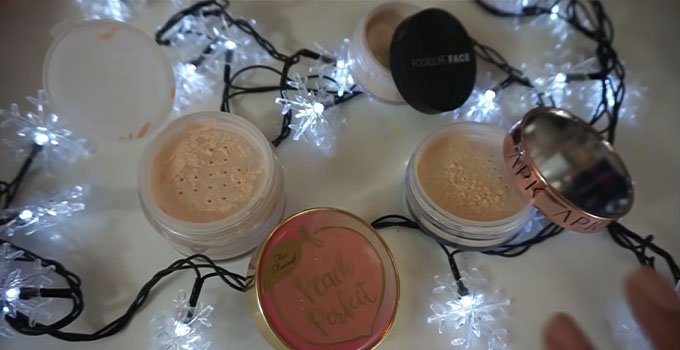 Face powders of different brands on white surface with lights